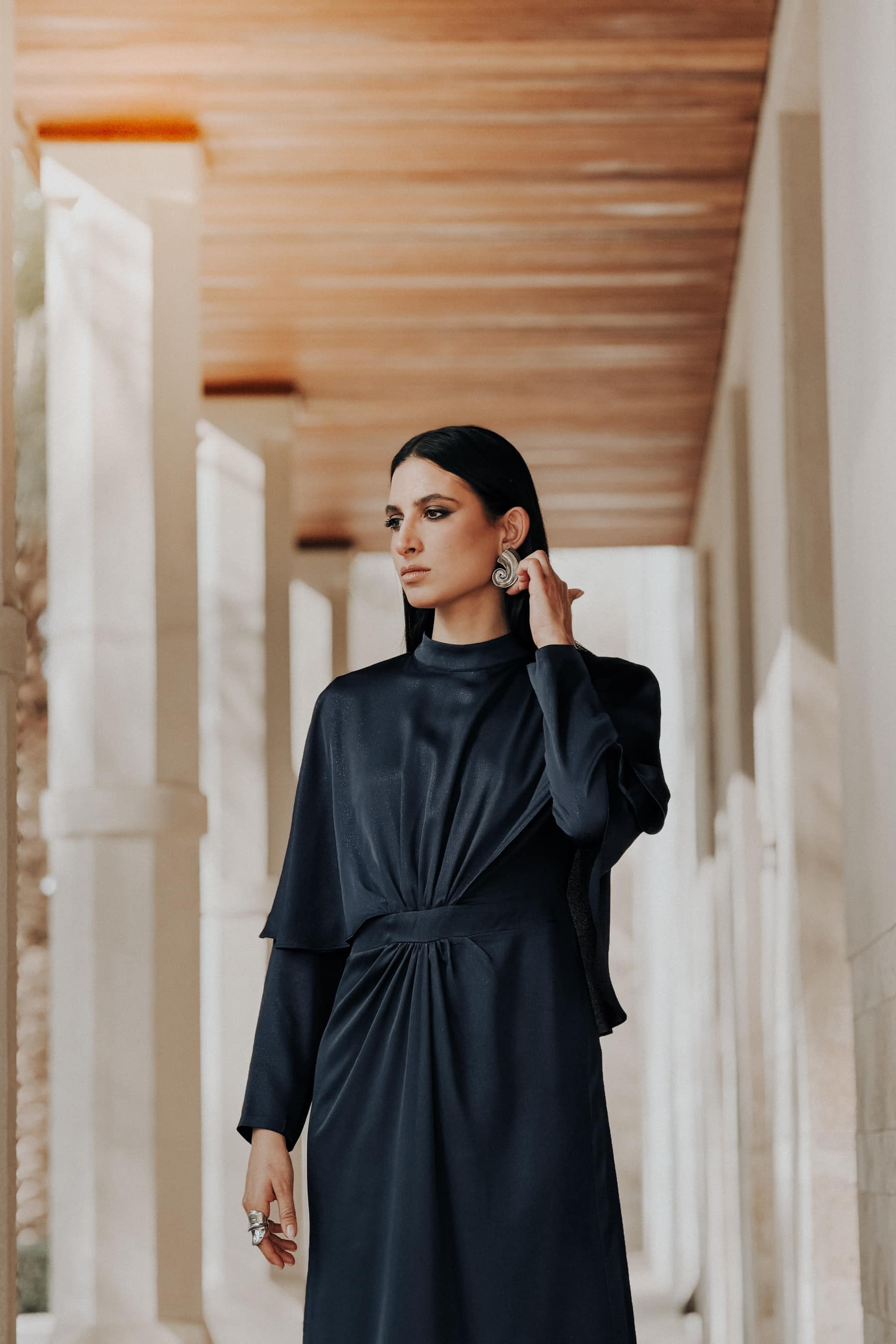 Model adjusting an earring in an arcade passage