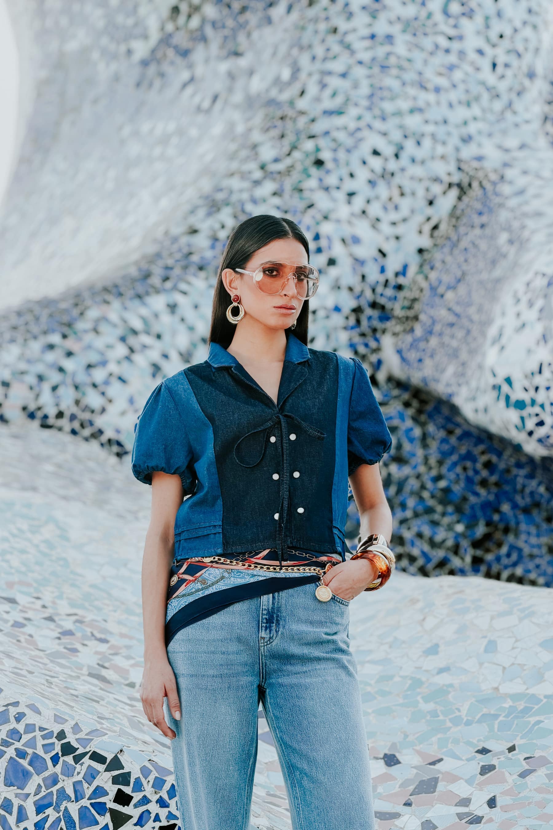 Model in denim against a blue mosaic wall